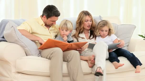 Famiglia carina guardando alcuni album in soggiorno — Video Stock