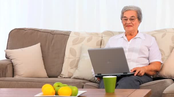 Äldre kvinna som arbetar på sin laptop — Stockvideo