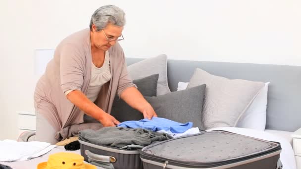 Ältere Frau bereitet ihr Gepäck vor — Stockvideo