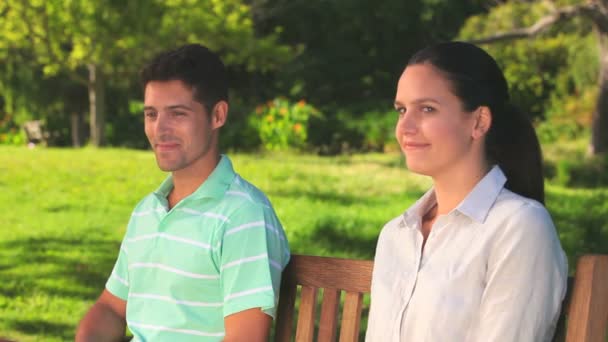 Liefdevol stel zittend op een bankje — Stockvideo