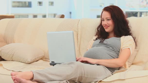 Pregnant woman working on her laptop — Stock Video