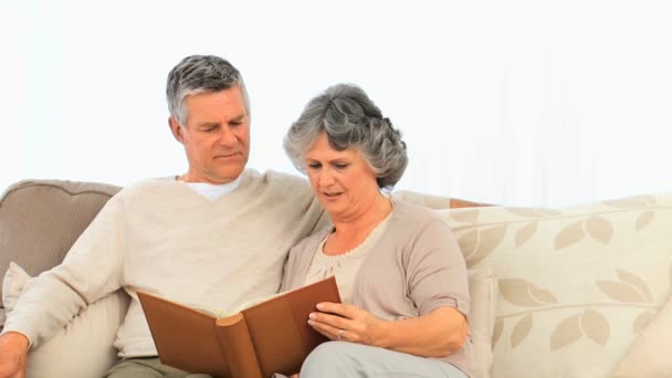 Senior couple looking at their photo album — Stock Video