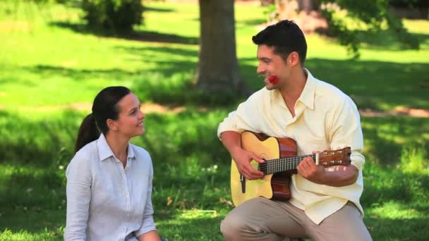 Homem tocando guitarra com uma rosa entre os dentes — Vídeo de Stock