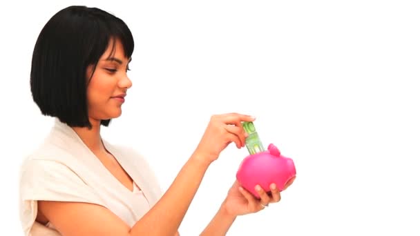 Asian woman putting on money in a piggy bank — Wideo stockowe