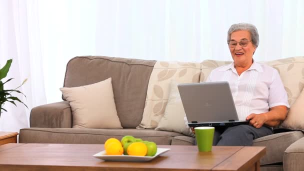 Mature woman laughing in front of her laptop — Stock Video