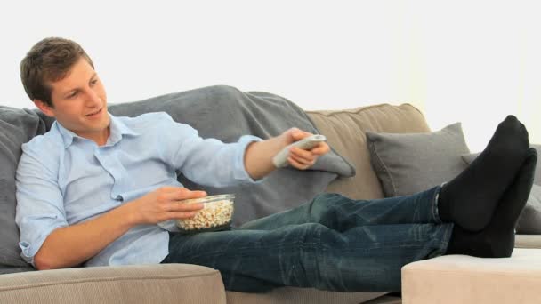 Hombre comiendo palomitas de maíz frente a la televisión — Vídeos de Stock