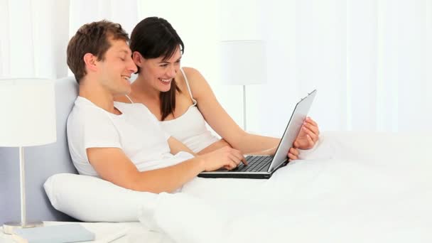 Happy young couple using a laptop — Stock Video