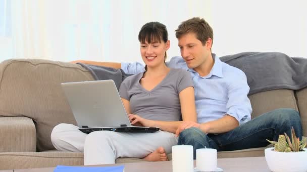 Attractive couple using a laptop — Stock Video