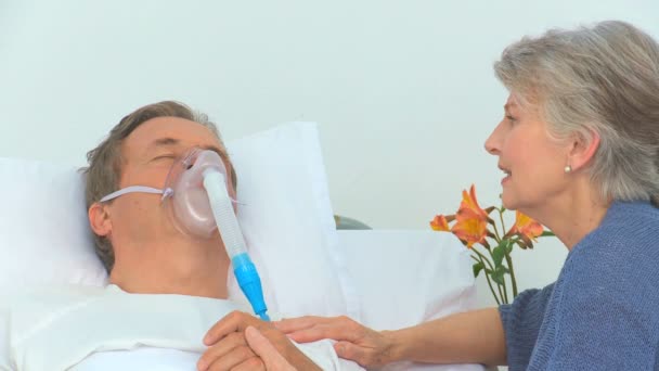 Mujer mayor hablando con su marido inconsciente — Vídeo de stock