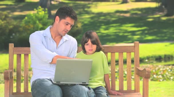 Padre e hijo con portátil al aire libre — Vídeo de stock