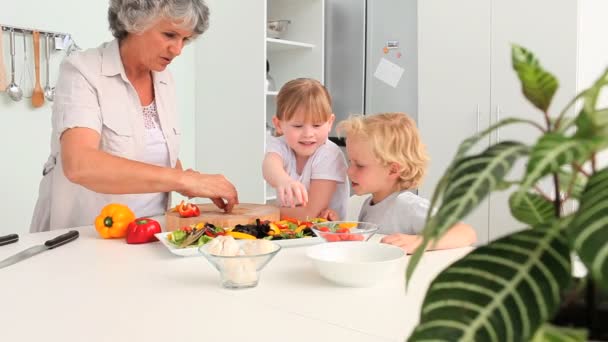 Kinderen koken met hun grootmoeder — Stockvideo