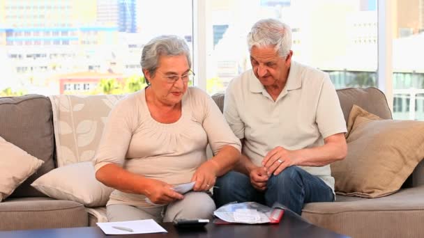 Parejas maduras calculando sus facturas domésticas — Vídeo de stock