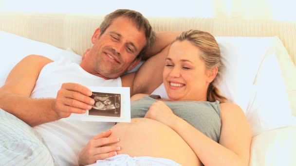 Man showing his pregnant wife a scan — Stock Video