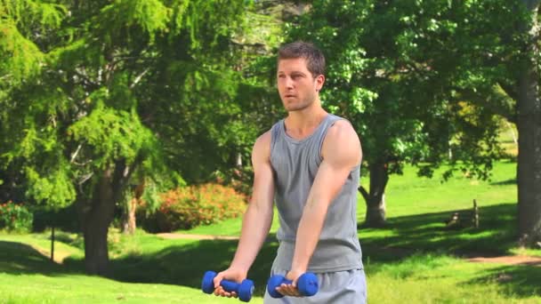 Young man using dumbells — Stock Video