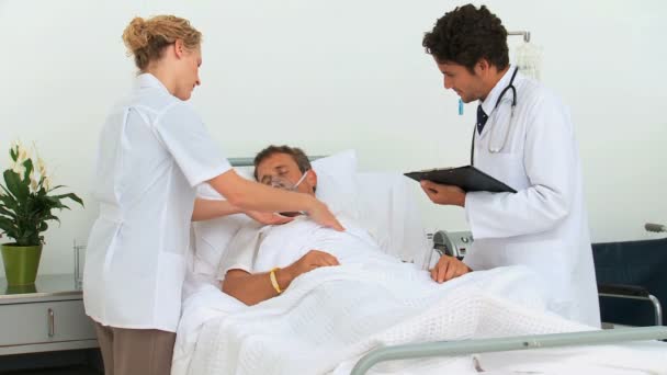 Пациент без сознания с двумя врачами — стоковое видео