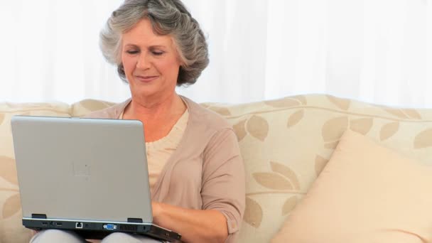 Gepensioneerde vrouw die op haar laptop werkt — Stockvideo