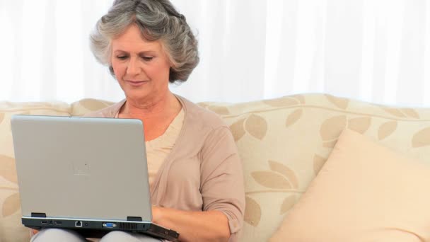 Stralende gepensioneerde vrouw kijken naar haar laptop — Stockvideo