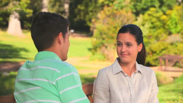 Pareja hablando en un banco del parque — Vídeos de Stock