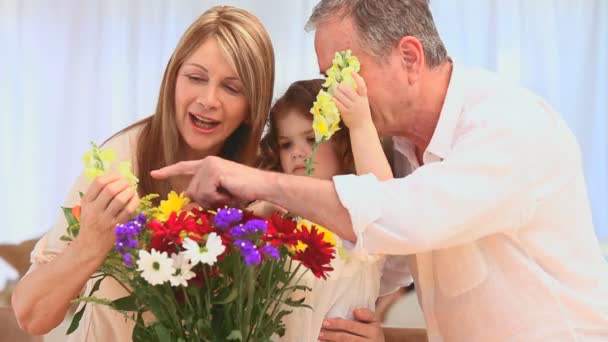 Familj att sätta på blommor i en vas — Stockvideo
