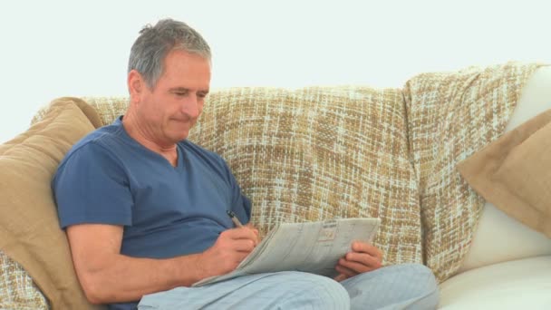 Retired man doing cross words — Stock Video