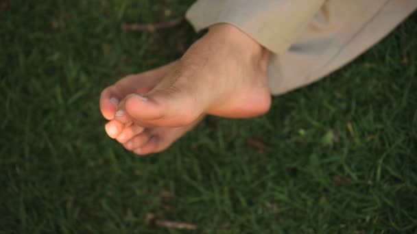 Um homem torcendo os dedos nus dos pés — Vídeo de Stock
