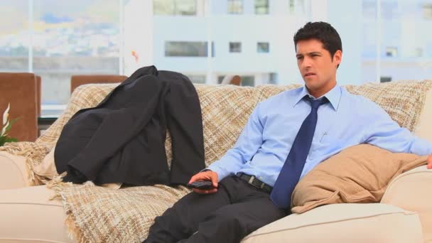 Tired businessman after work sitting on his sofa — Stock Video