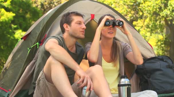 Atractiva pareja mirando a través de prismáticos — Vídeo de stock