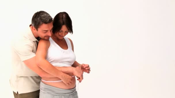 Мужчина измеряет брюхо беременной жены — стоковое видео