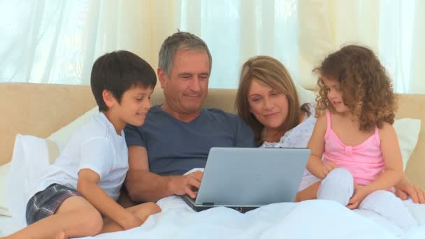 Οικογένεια κοιτάζοντας ένα φορητό υπολογιστή — Αρχείο Βίντεο