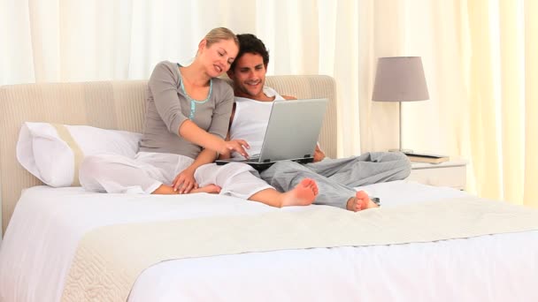 Jovem casal lindo usando em um laptop — Vídeo de Stock