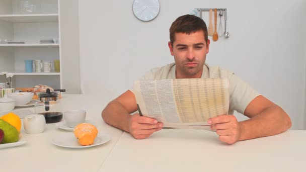 Hombre leyendo su periódico en la cocina — Vídeos de Stock