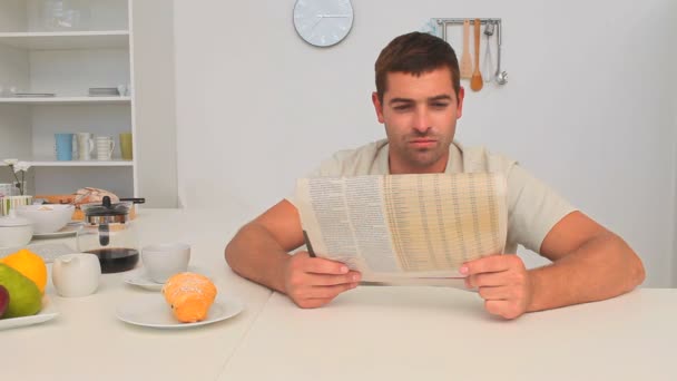 Man reading his newspaper in the kitchen — Stock Video