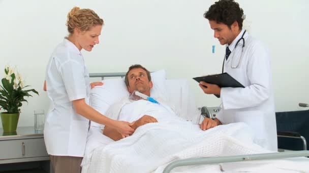Doctors examining a sick man — Stock Video
