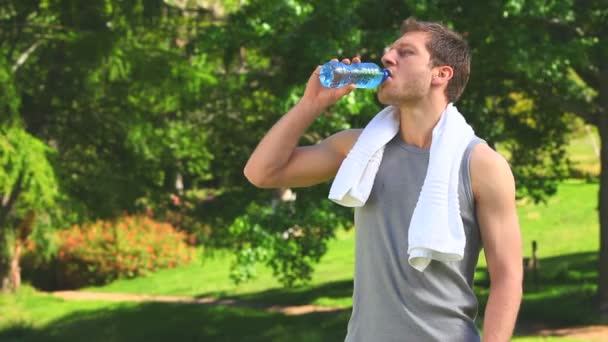 Hombre de pelo oscuro con una botella de agua y toalla — Vídeos de Stock