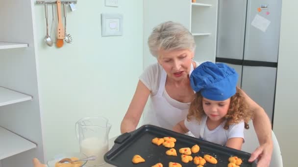 Grootmoeder en haar kleindochter proberen cookies — Stockvideo