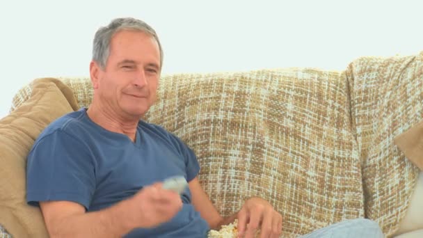 Uomo maturo guardando la tv con popcorn — Video Stock