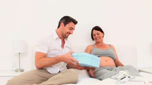 Мужчина дарит подарок своей беременной жене — стоковое видео