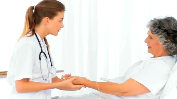 美丽的护士考虑她的病人的脉搏 — 图库视频影像