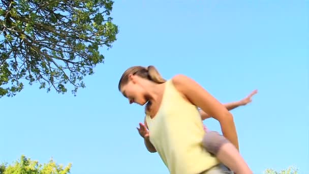 Жінка з дочкою на спині — стокове відео