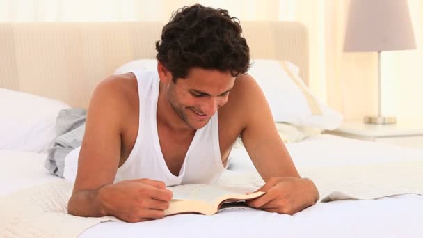 Homme en pyjama lisant un livre — Video