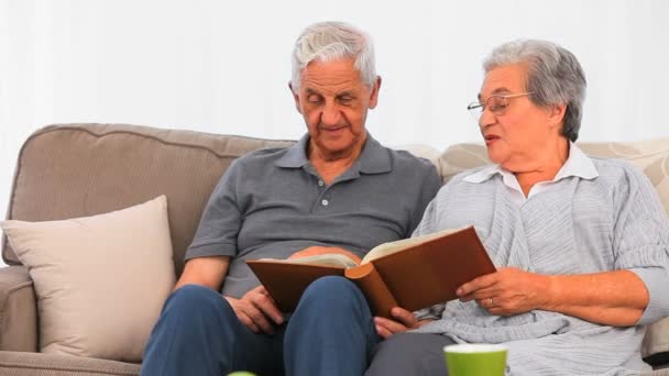 Senior couple looking at their photo album — Stock Video