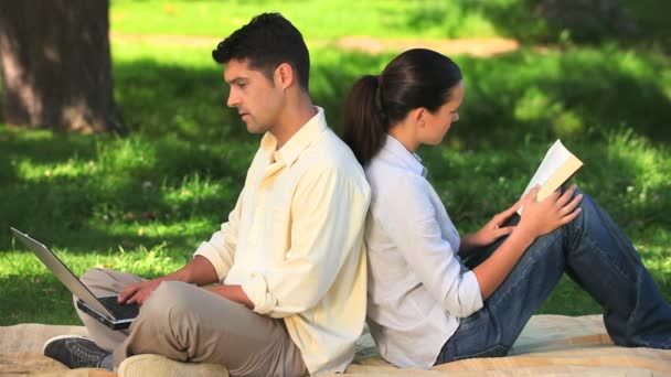 Couple en utilisant un ordinateur portable et la lecture — Video