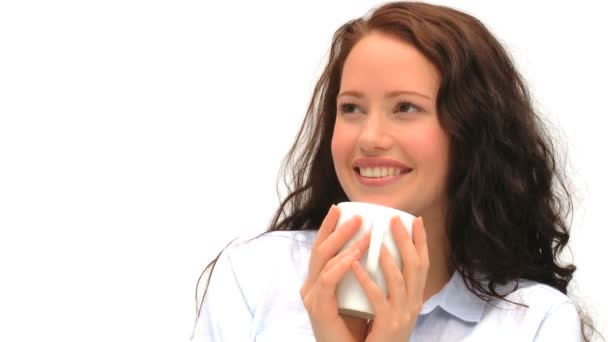 Mujer bebiendo una taza de café sobre un fondo blanco — Vídeo de stock