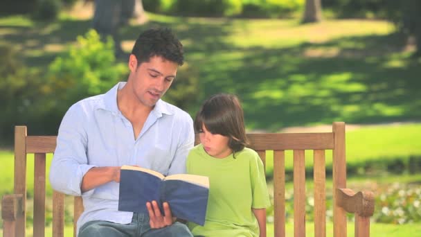 Vader lezen van een boek met zijn zoon — Stockvideo