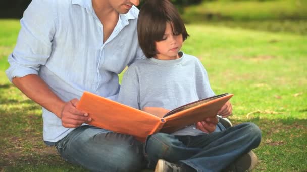 Vater und Sohn lesen Outdoor-Bücher — Stockvideo