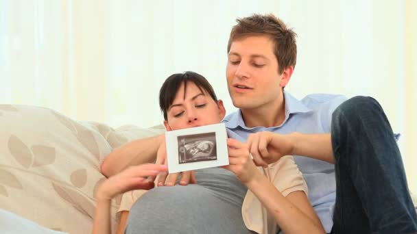 Jeune couple regardant le scan de leur futur bébé — Video