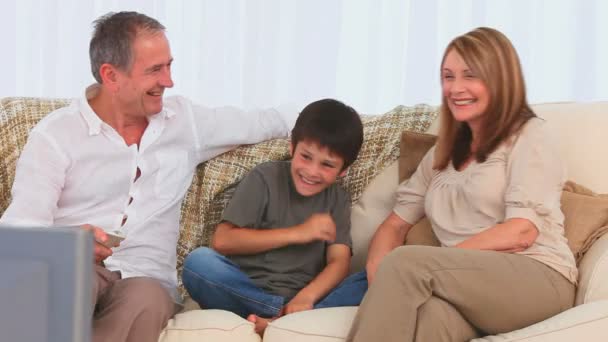 Família rindo na frente da TV — Vídeo de Stock