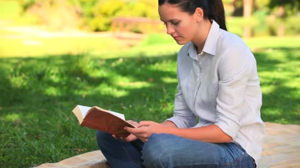 Vrouw vergadering lezen buitenshuis — Stockvideo