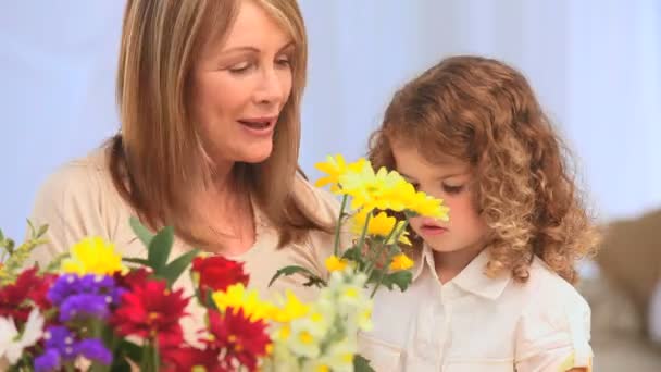 En mormor med hennes dotterdotter att göra en massa blommor — Stockvideo