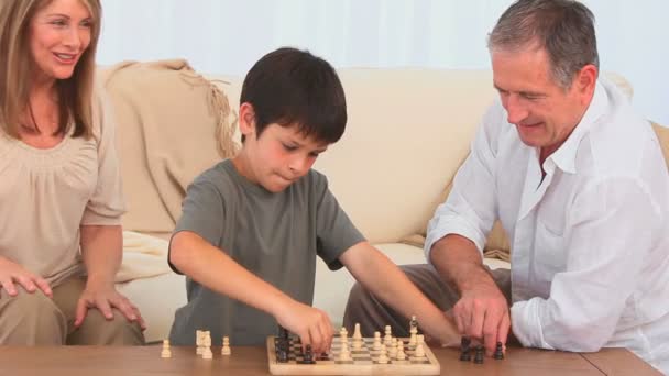 Игра в шахматы между дедушкой и внуком — стоковое видео